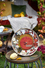 Handmade autumn wall clock decorated with dried flowers, moss and mini pumpkins. Rustic seasonal home decor with inscription Hello Fall, perfect for cozy fall interior or gift.