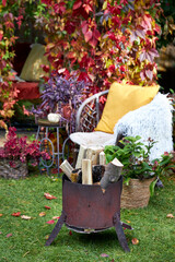 Cozy autumn terrace with rustic decor, wicker chairs, colorful pillows, firewood basket, and seasonal pumpkins. Decorative plants and vibrant fall foliage create a warm, inviting outdoor retreat, perf
