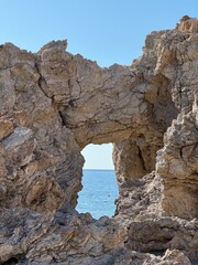 sea seen through a hole in beautiful clay rocks in rhodos, greece