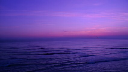 Purple ocean horizon at dusk with soft waves and a vibrant sky, a serene seascape view