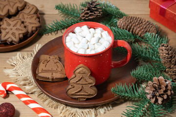 Warm holiday cocoa with marshmallows and festive cookies on a cozy wooden table
