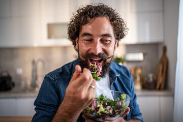Happy man enjoying eating fresh healthy salad