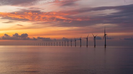 Stunning sunset over wind farm at sea, a powerful symbol of sustainable energy and environmental responsibility creating a vibrant and modern skyline