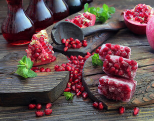 A beautiful ripe pomegranate on a dark wooden table. A variety of conceptual photos of pomegranates. Variable ideas for creating a look.