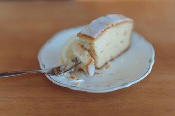 Eating a delicate lemon drizzle cake slice at cafe