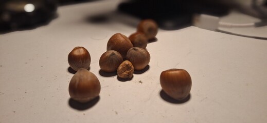 A handful of whole hazelnuts on a table, illuminated by warm light. Symbolizing healthy snacks,...