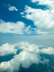 Floating above the clouds with a bright blue sky and soft white formations during a sunny day