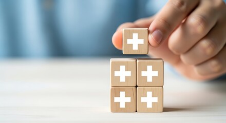 Hand stacking wooden blocks with plus sign isolated on white background
