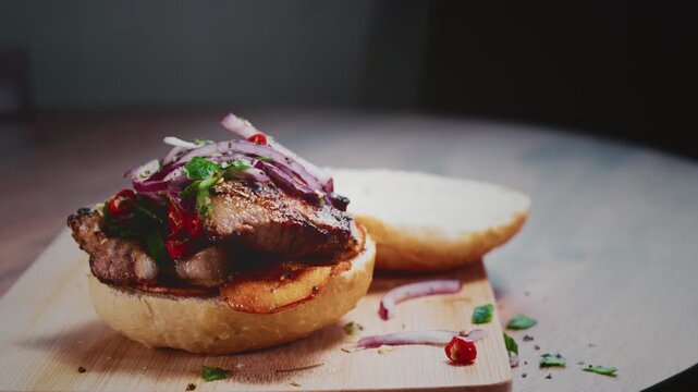 Cook puts a salad or salsa sauce on the pork burger. Chef adds red marinated onions to his morning sweet potato sandwich. Homemade traditional Peruvian cuisine. Pan con chicharron