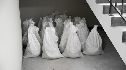 Construction waste in white bags stands in the entrance