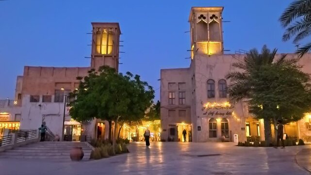 Dubai, UAE, 28.05.2025. Al Seef Dubai Creek historical heritage Area. Vintage Vibe of the traditional arab architecture, watchtowers on the pier. Night Al Seef Slow motion