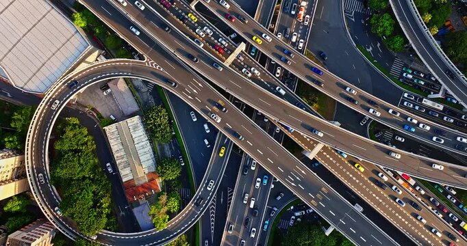 Aerial shot of a multi-level highway interchange with busy vehicle traffic creating a complex urban transportation network in Guangzhou, China.