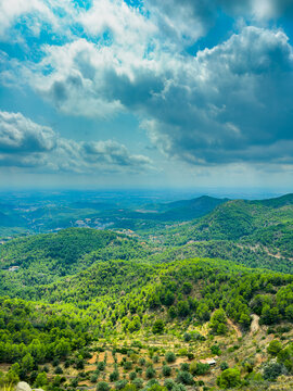 Fototapeta Scenic landscape view from a hilltop with lush green forests and distant mountains under a cloudy sky