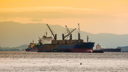 Fototapeta premium Cargo ship at sea during sunset.