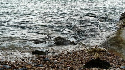 Seawater waves hitting coastal rocks.