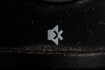Tv mute icon and button close up of a old black Television remote controller