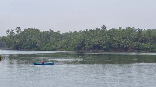 locked shot of man rowing a canoe fishing on the backwaters of bekal kerala showing how the lives are tied to the oceans and saltwater rivers across cities