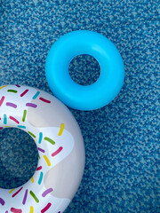 Pool float donut and blue circle in swimming pool. Water safety.  Top view. 