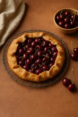 A delicious cherry tart, a baked dessert, sits atop a rustic wire rack