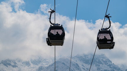 A cable car against the backdrop of a mountain range on a cloudy autumn day
