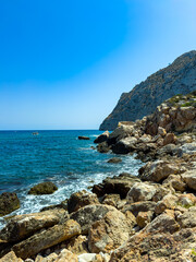 Breathtaking coastal scene with rocky shoreline and clear blue water under a bright sky on a sunny day at the beach