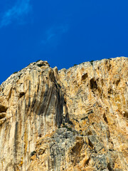 Fototapeta premium Stunning rock formation under a clear blue sky in a mountainous landscape during a sunny day