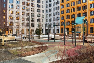 Urban courtyard with playground and apartment houses. Residential complex with play area. Play equipment and housing. Apartment building playground. Urban city living space with play structure