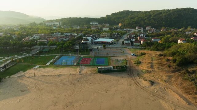 Drone sliding left overviewing Agva Merkez coastal resort town early in the morning.