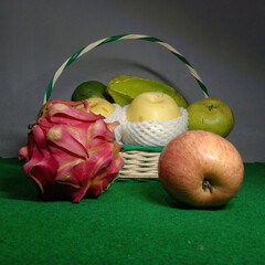 Fruits are placed in a parcel basket that has a curved handle
