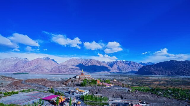 The sacred Diskit Monastery statue stands tall on a mountaintop in the vast valley Himalayas. Diskit Gompa is the oldest and largest Buddhist monastery in the Nubra Valley of Ladakh, northern India.