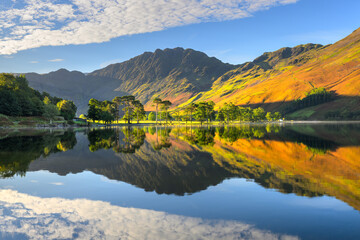 Fototapeta premium Beautiful autumn reflections at Buttermere on a sunny morning with calm reflections, Lake District, UK.