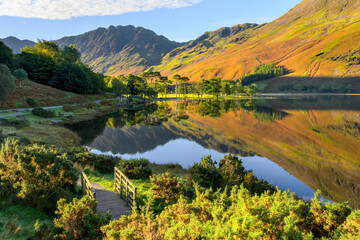 Beautiful autumn morning with reflections at Buttermere Lake in The Lake District, UK.