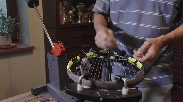 Manual stringing of a tennis racket on machine	