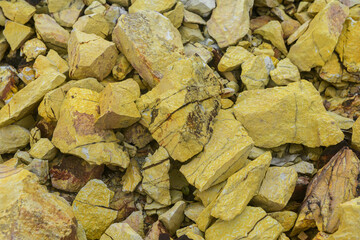 Close-up of sulfur mineral rocks in yellow tones.