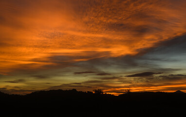 Beautiful sunset sky over land with glowing clouds.
