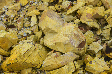 Close-up of sulfur mineral rocks in yellow tones.