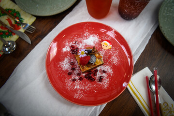 Coffee cake served on a red plate with cutlery.