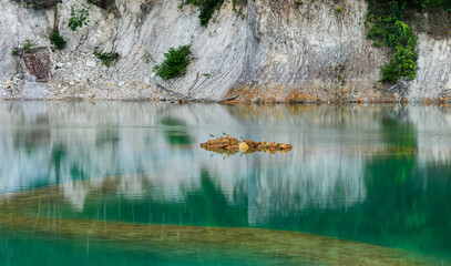 Abandoned quarry pond with green turquoise water.