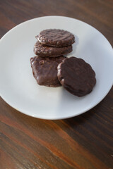 Biscuits covered with chocolate on both sides on a white plate