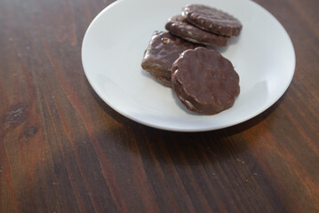 Biscuits covered with chocolate on both sides on a white plate