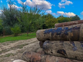 Multiple pipes in outdoor area surrounded by greenery showing industrial storage and material readiness for future construction use.