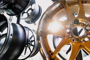 Gold Wheel Alloy Wheels Rim or Mag Wheel high performance auto part decoration. Stand with alloy wheels in modern tire store.