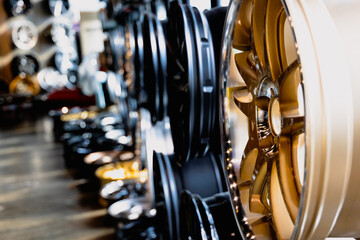 Gold Wheel Alloy Wheels Rim or Mag Wheel high performance auto part decoration. Stand with alloy wheels in modern tire store.