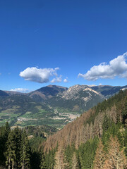 Obraz premium Mountain town surrounded by green valley and rocky peaks