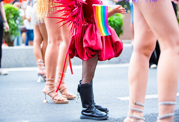 A cropped photo shows the lower body of female participants at the Nha Trang Sea Festival parade, featuring elements of their costumes, detailed accessories, and extravagant footwear.
