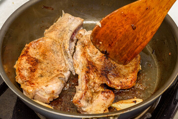 Close-up of frying meat with onions in a frying pan.