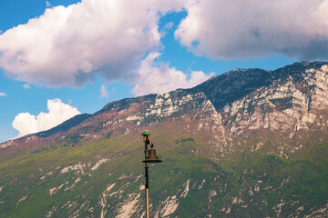 Limone, Italy Apr 28, 2025. Lantern at the harbour of Limone sul Garda with the snow-capped mountains in the background, located on Lake Garda.