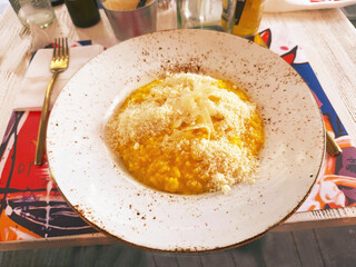 Risotto alla Milanese. Delicious Italian risotto with saffron and Grana Padano, is a hard cheese from the Po Valley. Lombard saffron risotto recipe in restaurant.