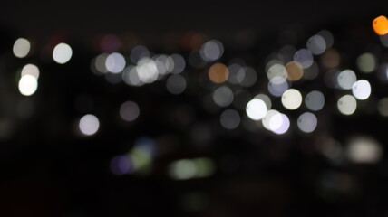 City lights glow softly, blurring into abstract shapes in the night sky, creating a serene and...