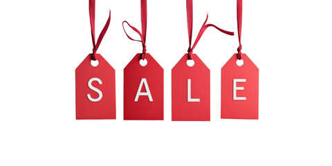 Red sale tags hanging on ribbons isolated on black background